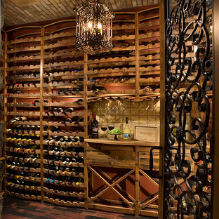 Foto de bodega mediterránea, extra grande, con suelo de madera oscura y botelleros