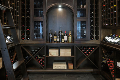 Wine cellar - mid-sized transitional slate floor wine cellar idea in Vancouver with diamond bins
