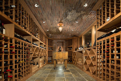 Réalisation d'une grande cave à vin tradition avec un sol en ardoise et un présentoir.