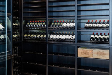 Photo of a contemporary wine cellar in Boston with display racks and beige floors.