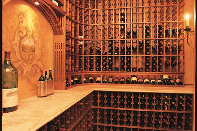 Wine cellar - large traditional terra-cotta tile wine cellar idea in Orange County with display racks