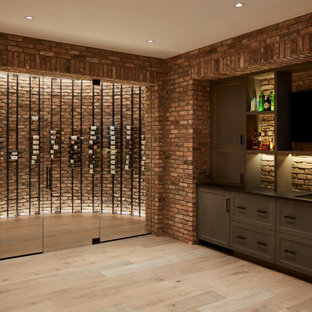 Immagine di una grande cantina country con parquet chiaro, portabottiglie a vista e pavimento grigio