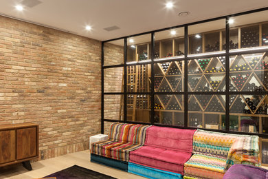 Design ideas for an eclectic wine cellar in London with light hardwood flooring and display racks.