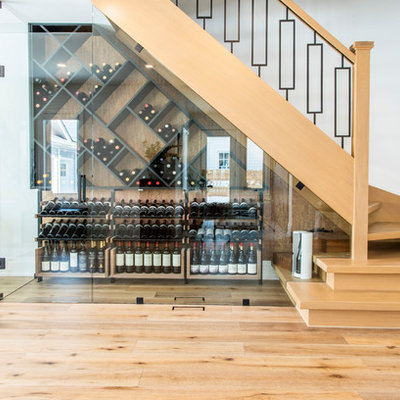 Mid-sized minimalist medium tone wood floor and brown floor wine cellar photo in Toronto with diamond bins
