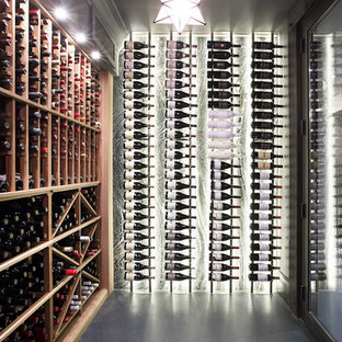 Esempio di una grande cantina minimal con pavimento in cemento, portabottiglie a scomparti romboidali e pavimento grigio