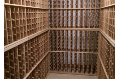 Huge elegant porcelain tile and beige floor wine cellar photo in New York with storage racks