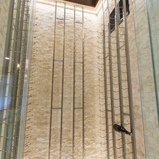 Idée de décoration pour une cave à vin design de taille moyenne avec un sol en travertin, un présentoir et un sol beige.