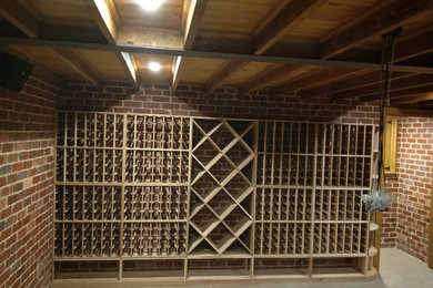 Cette photo montre une cave à vin chic de taille moyenne avec sol en béton ciré, des casiers et un sol gris.