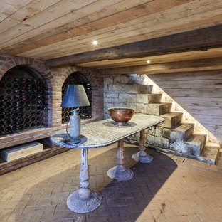 Immagine di una cantina country di medie dimensioni con rastrelliere portabottiglie e pavimento in mattoni