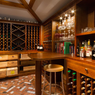 Classic wine cellar in Devon with brick flooring, cube storage and red floors.