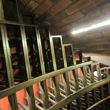 Racking stair steps down the slanted custom wine cellar Texas ceiling