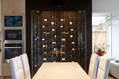 This is an example of a medium sized contemporary wine cellar in Vancouver with medium hardwood flooring, cube storage and brown floors.