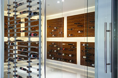 Example of a large minimalist porcelain tile and white floor wine cellar design in Vancouver with diamond bins