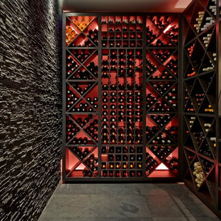 Aménagement d'une petit cave à vin contemporaine avec un sol en ardoise et des casiers.