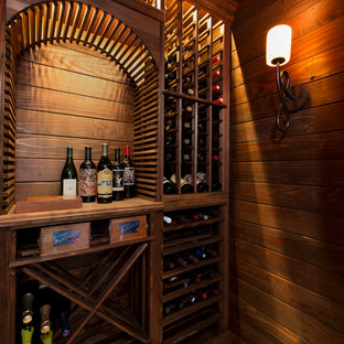 Idee per una piccola cantina stile rurale con pavimento in travertino, portabottiglie a scomparti romboidali e pavimento beige
