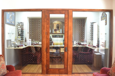 Inredning av en klassisk stor vinkällare, med mellanmörkt trägolv, vinhyllor och brunt golv