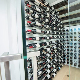 Idee per una cantina contemporanea di medie dimensioni con pavimento in laminato e portabottiglie a vista