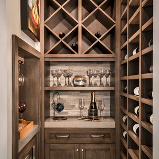 Ejemplo de bodega clásica renovada, pequeña, con suelo de baldosas de porcelana, botelleros y suelo beige