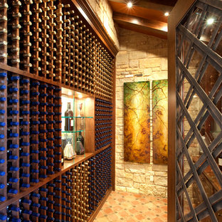 Esempio di una cantina mediterranea con rastrelliere portabottiglie e pavimento arancione
