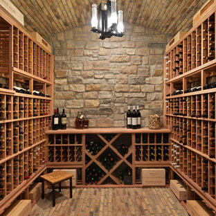 Foto de bodega tradicional, de tamaño medio, con suelo de ladrillo y botelleros