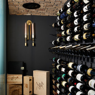 Immagine di un'ampia cantina minimal con pavimento in vinile, portabottiglie a vista e pavimento nero