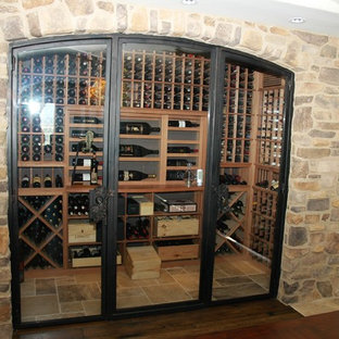 Idee per una piccola cantina design con pavimento in terracotta e portabottiglie a vista