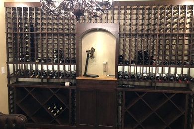 Wine cellar - large traditional medium tone wood floor and brown floor wine cellar idea in Denver