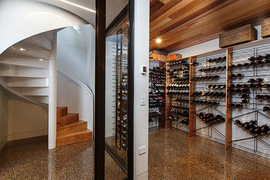 Large contemporary wine cellar in Melbourne with travertine flooring and storage racks.