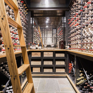 Example of a mid-sized urban gray floor and slate floor wine cellar design in Other with diamond bins