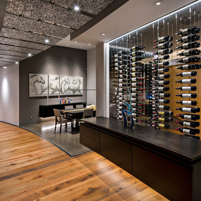 Example of a huge trendy medium tone wood floor and brown floor wine cellar design in Phoenix with storage racks