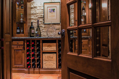 Wine cellar - large traditional terra-cotta tile wine cellar idea in Chicago with storage racks