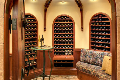 Large rustic wine cellar in San Francisco with limestone flooring, storage racks and beige floors.