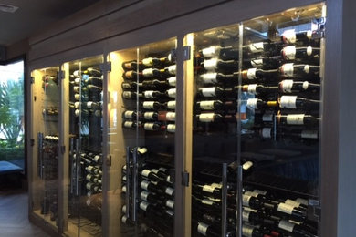 Wine cellar - large contemporary medium tone wood floor wine cellar idea in Orange County with display racks