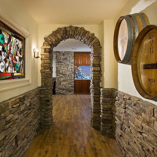 Foto di una cantina stile rurale di medie dimensioni con pavimento in legno massello medio e portabottiglie a vista