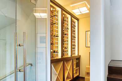 Wine cellar - mid-sized modern dark wood floor and brown floor wine cellar idea in San Francisco with storage racks