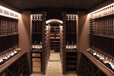 Idée de décoration pour une grande cave à vin chalet avec un sol en brique, des casiers et un sol beige.