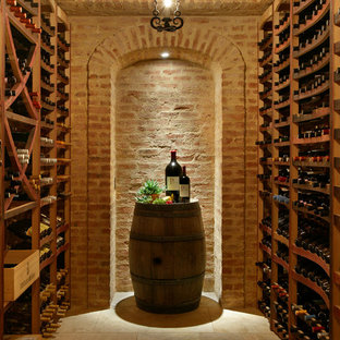 Immagine di una cantina mediterranea con rastrelliere portabottiglie e pavimento beige