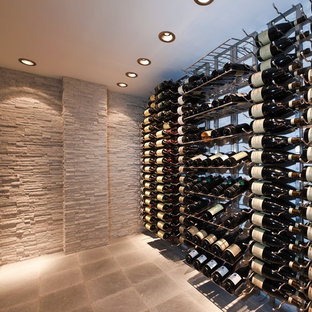 Ispirazione per una grande cantina chic con portabottiglie a vista, pavimento in cemento e pavimento grigio
