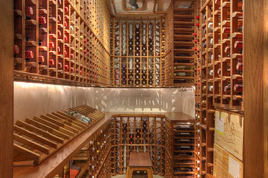Example of a huge mountain style slate floor wine cellar design in New York with display racks