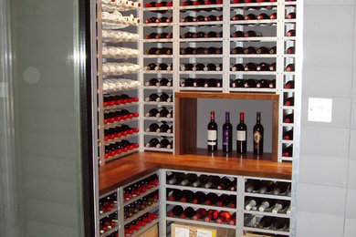 Example of a small trendy wine cellar design in Surrey with storage racks