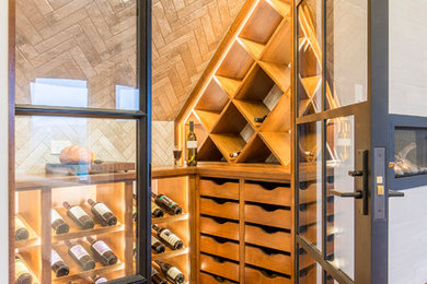 Modern inredning av en mellanstor vinkällare, med mellanmörkt trägolv och vinställ med diagonal vinförvaring