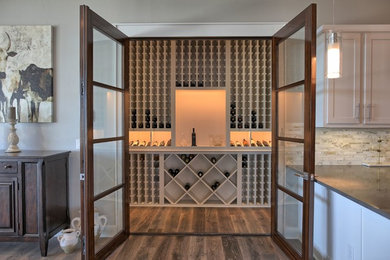 Transitional medium tone wood floor and brown floor wine cellar photo in Austin with display racks
