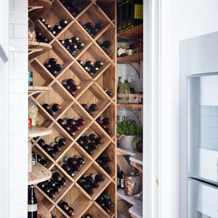 Imagen de bodega campestre, pequeña, con suelo de madera oscura, botelleros de rombos y suelo marrón