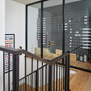 Immagine di una grande cantina minimal con parquet chiaro, rastrelliere portabottiglie e pavimento beige