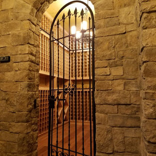 Idée de décoration pour une cave à vin tradition de taille moyenne avec des casiers, un sol en bois brun et un sol beige.