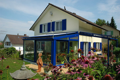 Blauer Holz-Alu Wintergarten mit passendem Terrassendach