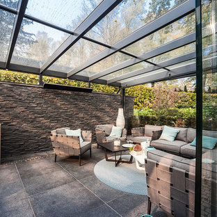 Großer Moderner Wintergarten ohne Kamin mit Betonboden, Glasdecke und grauem Boden in Hamburg