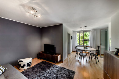 Réalisation d'un salon design de taille moyenne avec un mur gris, un sol en bois brun, un téléviseur encastré et un sol marron.