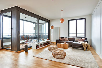 Mittelgroßes, Offenes Modernes Wohnzimmer mit weißer Wandfarbe, braunem Holzboden und braunem Boden in Hamburg