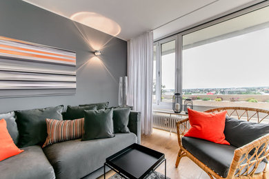 This is an example of a medium sized contemporary open plan games room in Munich with grey walls, medium hardwood flooring, a built-in media unit and brown floors.